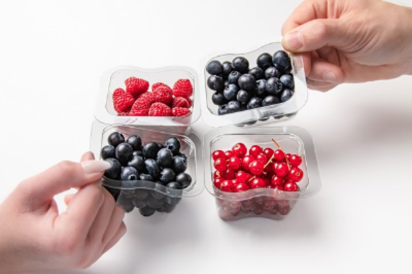 Several small, separable plastic trays with berries being pulled apart by hands.