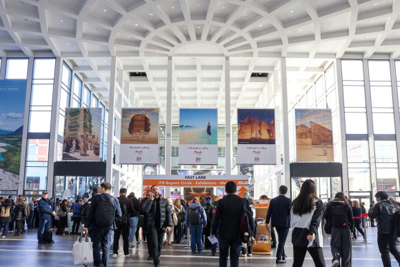 Vestíbulo concurrido en la entrada sur del recinto de exposiciones de Berlín en ITB Berlín: los visitantes se agotan en la sala bien iluminada, con carteles a gran escala de destinos.