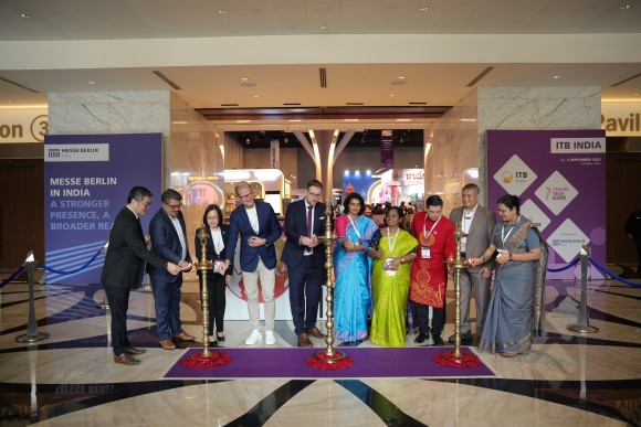 Ten participants perform the official lamp lighting ceremony in front of the event backdrop
