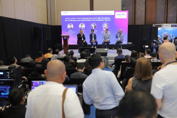 Delegates gather at the registration counter during Travel Meet Asia, engaging with staff and checking in for the event in a bright, modern venue.