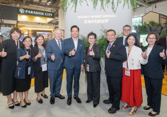 Three people are talking during the VIP opening tour of ITB Asia 2025 at the Resorts World Sentosa booth, the Official Integrated Resort Partner of the event.